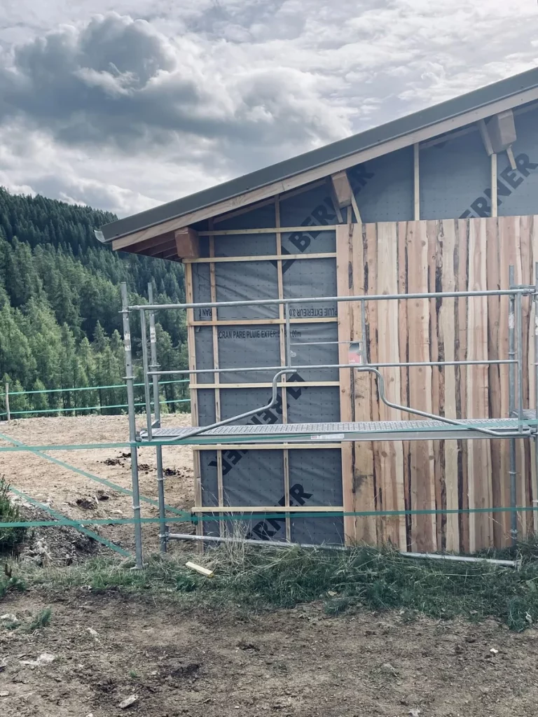 Ossature bois avec pare-pluie et bardage bois vertical en cours de pose