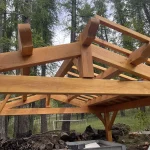 Charpente traditionnelle d'un abri en bois pour véhicule, en haute montagne