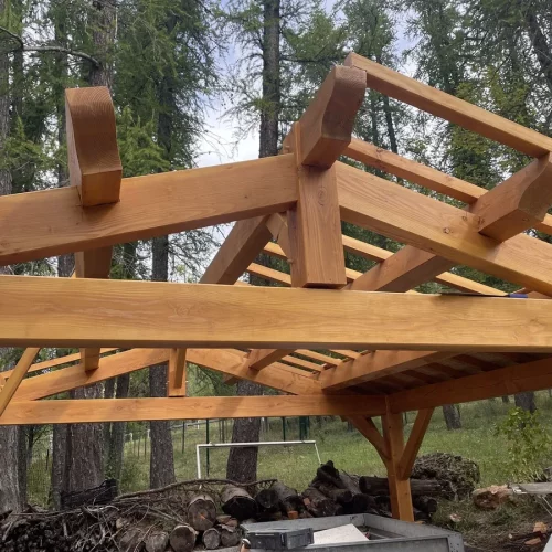 Charpente traditionnelle d'un abri en bois pour véhicule, en haute montagne