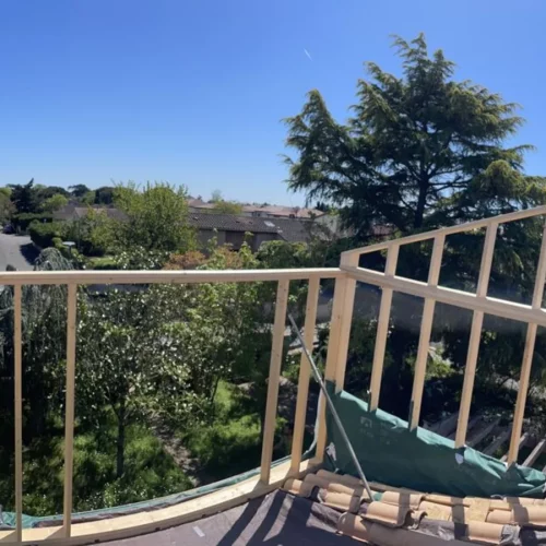Chantier d’ossature bois en hauteur, au-dessus des jardins d’un quartier résidentiel
